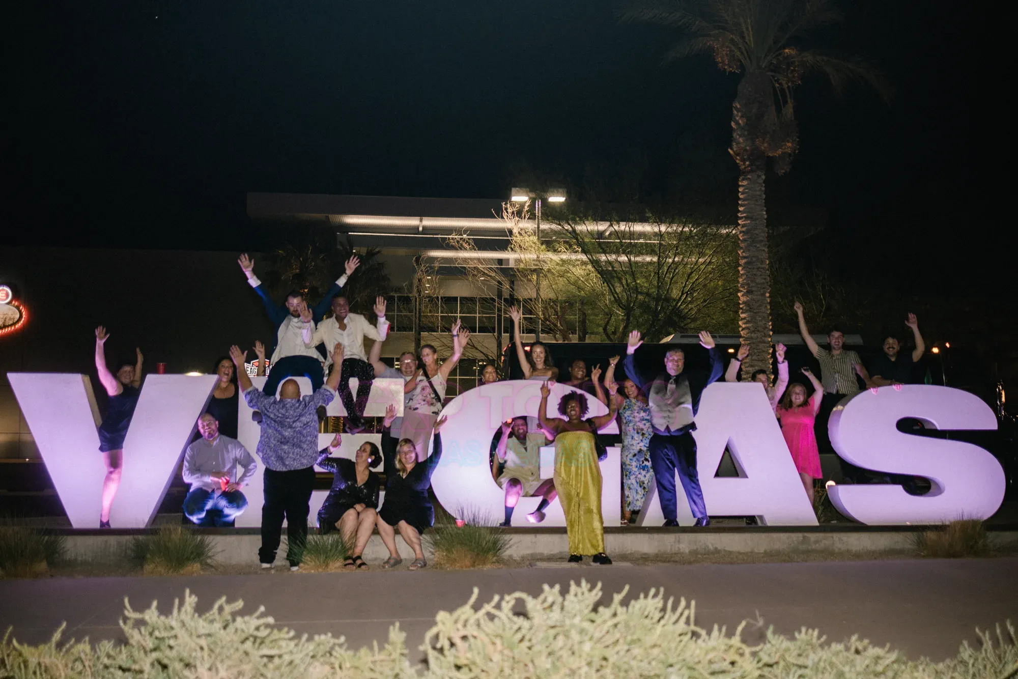 Corporate incentive team celebrating at the Las Vegas letters on a GXP Tours private night